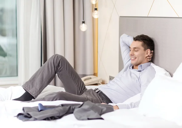 Feliz mujer de negocios acostada en la cama en la habitación de hotel —  Fotos de Stock