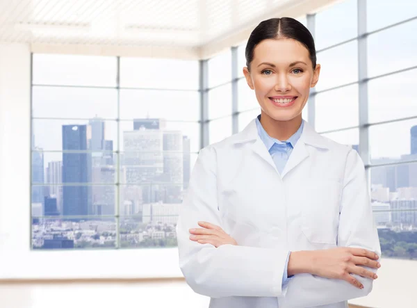 Jeune femme médecin souriante en manteau blanc — Photo