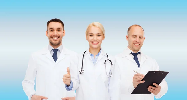 Группа врачей, показывающих большие пальцы в клинике — стоковое фото