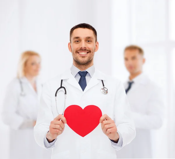 Lachende mannelijke arts met rood hart — Stockfoto
