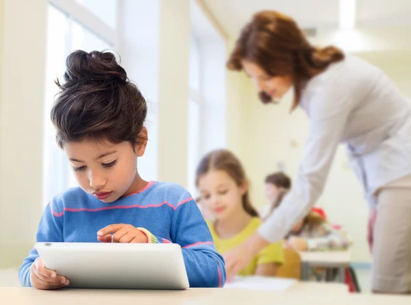 Liten skolflicka med TabletPC över klassrummet — Stockfoto