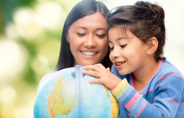 Heureux mère et fille avec globe — Photo