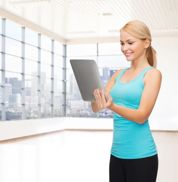Leende kvinna med TabletPC i gym — Stockfoto