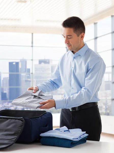 Homem de negócios embalando roupas em saco de viagem — Fotografia de Stock