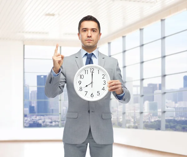 Homem de negócios de terno segurando relógio com 8 oclock — Fotografia de Stock