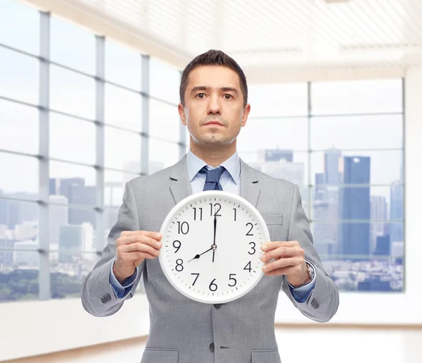 Homem de negócios de terno segurando relógio com 8 oclock — Fotografia de Stock