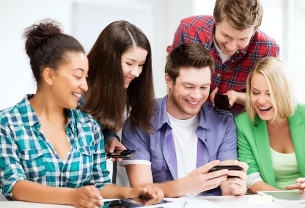 Studenten kijken naar smartphone op school — Stockfoto