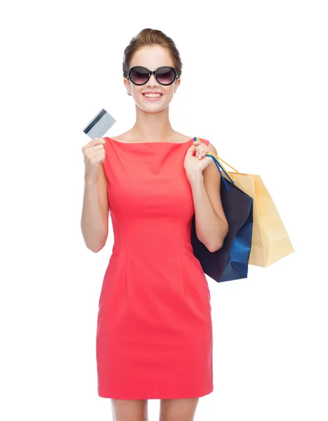 Mujer sonriente con bolsas de compras y tarjeta de plástico —  Fotos de Stock