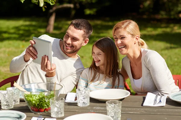 Ευτυχισμένη οικογένεια με pc ταμπλετών στο τραπέζι στον κήπο — Φωτογραφία Αρχείου
