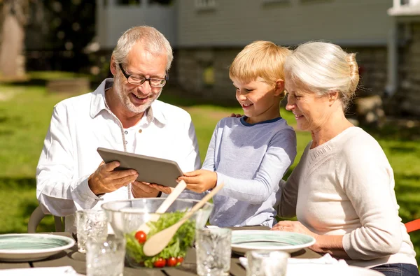 Família feliz com tablet pc ao ar livre — Fotografia de Stock