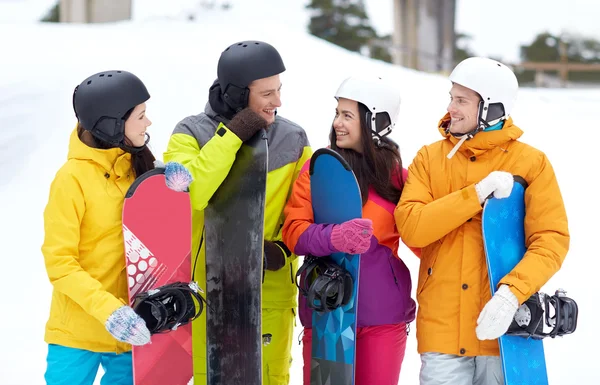 Happy vrienden in helmen met snowboards praten — Stockfoto