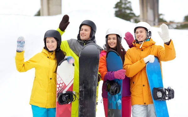 Gelukkige vrienden in helmen met snowboards — Stockfoto