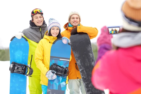 Amis heureux avec snowboards et smartphone — Photo