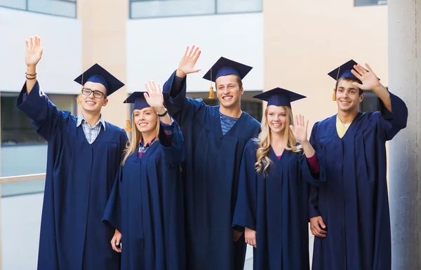 Grup gülümseyen öğrenci mortarboards içinde — Stok fotoğraf