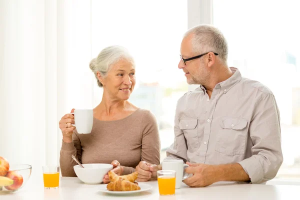 happy senior couple having breakfast at home