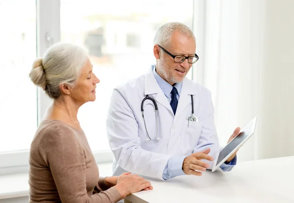 Lächelnde Seniorin und Ärztin mit Tablet-PC — Stockfoto
