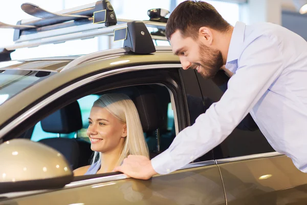 Casal feliz comprar carro em auto show ou salão — Fotografia de Stock