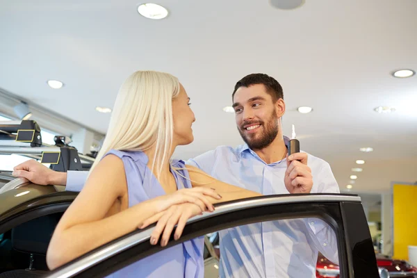 Feliz pareja comprando coche en auto show o salón —  Fotos de Stock