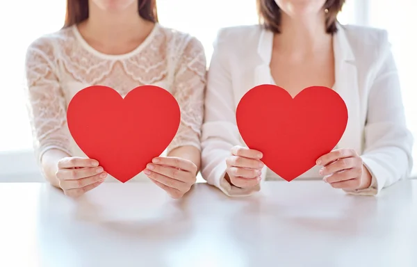 Рядом счастливая лесбийская пара с красными сердцами — стоковое фото
