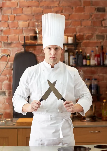 Šťastný muž šéfkuchaře vařit v kuchyni s nožem — Stock fotografie
