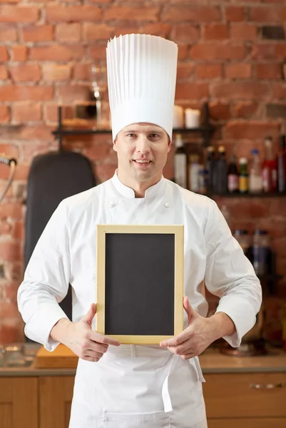 Szczęśliwy szef mężczyzna z puste menu płyty w kuchni — Zdjęcie stockowe