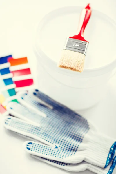 Paintbrush, paint pot, gloves and pantone samples — Stock Photo, Image