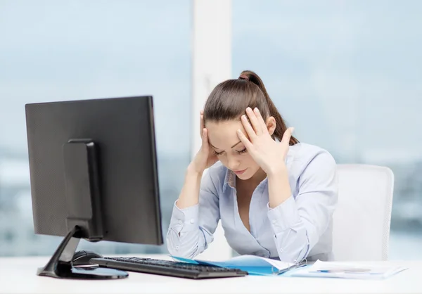 Mulher estressada com computador e documentos — Fotografia de Stock
