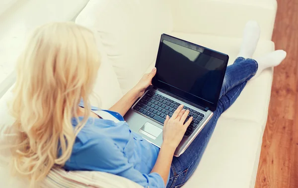 Donna sorridente con computer portatile a casa — Foto Stock