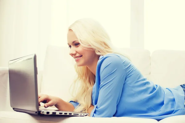 Mulher sorridente com computador portátil em casa — Fotografia de Stock