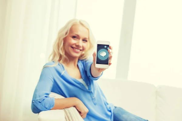 Mujer sonriente con smartphone en casa —  Fotos de Stock