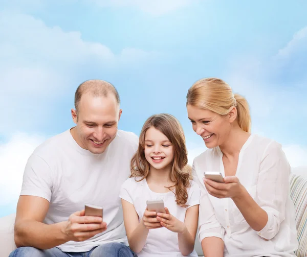 Happy family with smartphones — Stock Photo, Image