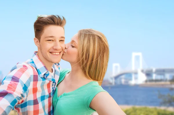 Pareja besándose y tomando selfie sobre puente — Foto de Stock