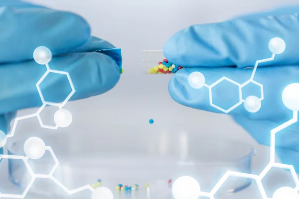 Закрыть руки учёного, держащего таблетки в лаборатории — стоковое фото