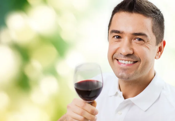 Homem feliz bebendo vinho tinto de vidro — Fotografia de Stock