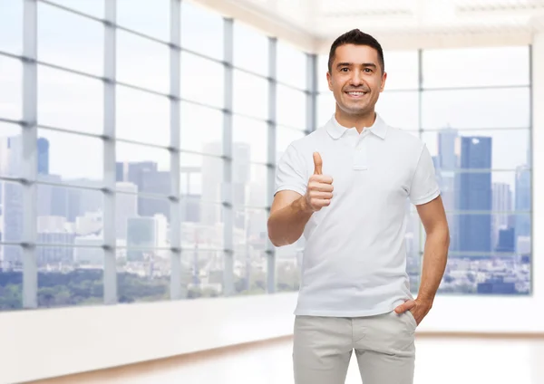 Улыбающийся мужчина показывает большие пальцы над офисом или домом — стоковое фото