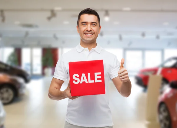 Sonriente hombre con rojo venta suspiro mostrando pulgares hacia arriba —  Fotos de Stock