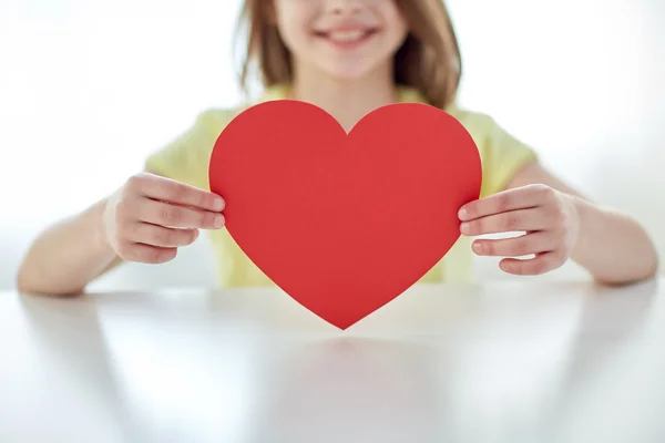 Perto de mãos de criança que mantêm o coração vermelho — Fotografia de Stock