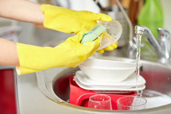 Close up de mulheres mãos lavar pratos na cozinha — Fotografia de Stock