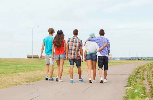 Group of teenagers walking outdoors from back — Stock Photo, Image