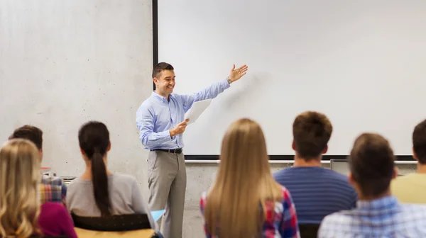 Groep studenten en lachende leraar met notitieblok — Stockfoto