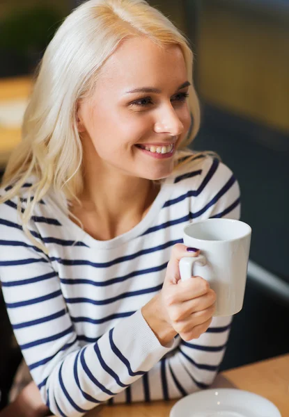 Glückliche junge Frau trinkt Tee oder Kaffee — Stockfoto