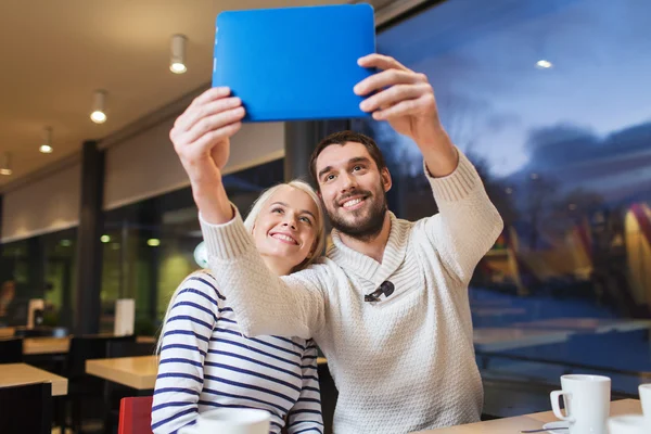 Feliz pareja con la tableta pc tomando selfie en la cafetería —  Fotos de Stock