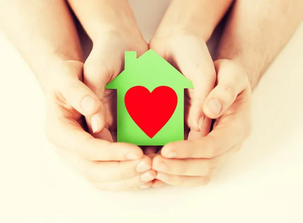 Coppia mani che tengono casa di carta verde — Foto Stock