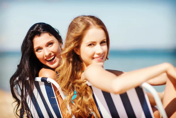 Meisjes om te zonnebaden op het strandstoelen — Stockfoto