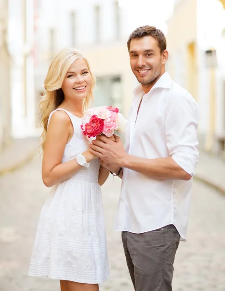 Couple with flowers in  city — Stock Photo, Image