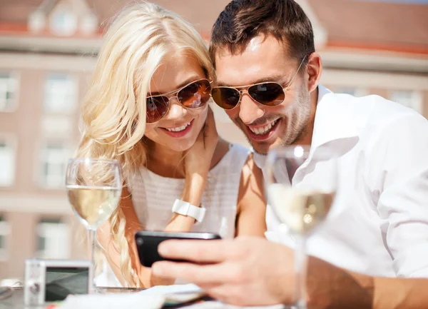 Couple looking at smartphone in cafe — Stock Photo, Image