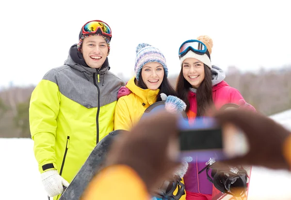 Friends with snowboards and smartphone