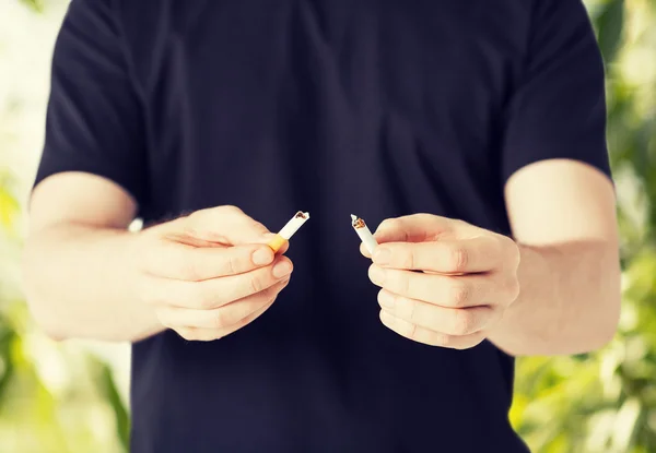 Man breaking  cigarette with hands — Stock Photo, Image