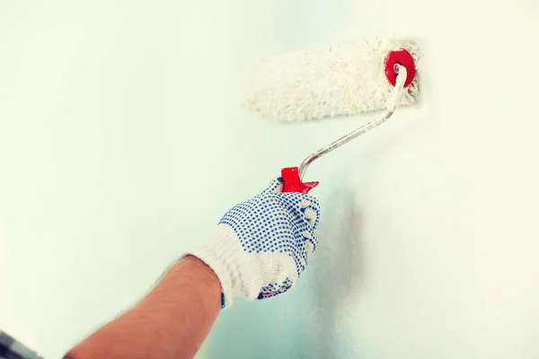 Man in handschoenen schilderij muur — Stockfoto