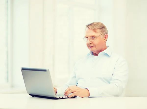 Oude man aan het werk met laptop — Stockfoto